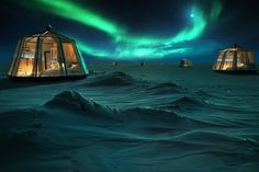 some tents in the snow under an aurora bore