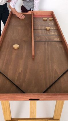 two men standing next to each other near a table with an air hockey board on it