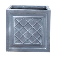 a square metal planter with an intricate design on the front and sides, in silver