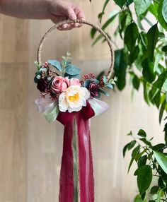 a person holding a flower arrangement in their hand