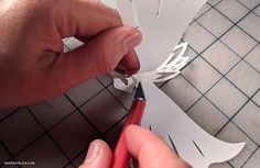 someone cutting out some paper with scissors