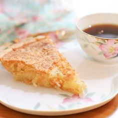 a piece of pie on a plate next to a cup of coffee