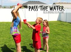 three young children are playing in the grass with a water jug and some straws