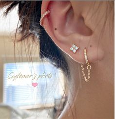 a close up of a person's ear with two different types of jewelry on it