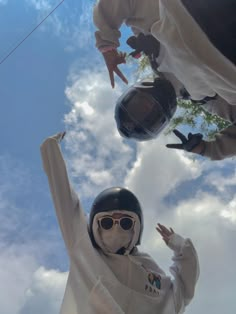 two people wearing protective gear and holding hands up in the air