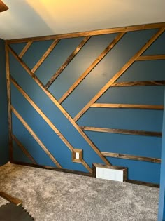 an empty room with blue walls and wood trimmings on the wall behind it