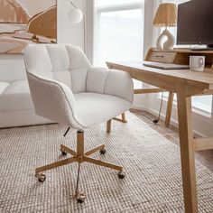 a white office chair sitting in front of a computer desk