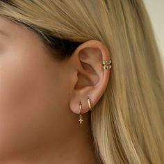 a close up of a woman's ear with two small crosses on the side