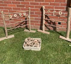 a basket filled with mushrooms sitting in the grass next to a brick wall and fence