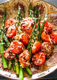 asparagus, tomatoes and parmesan cheese on a plate with floral designs