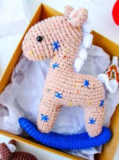 a crocheted toy horse in a box