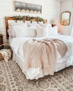 a bed with blankets and pillows in a bedroom next to a rug on the floor