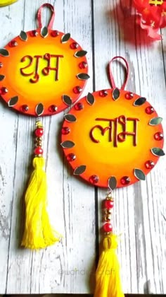 two orange plates with tassels hanging from them on a white wooden table next to fruit