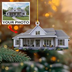 a house ornament hanging from a christmas tree