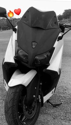 black and white photograph of a motorcycle with hearts on the back tire, parked in a parking lot