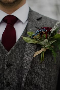 a man wearing a suit and tie with a boutonniere