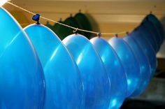 several blue balloons are hanging from a line