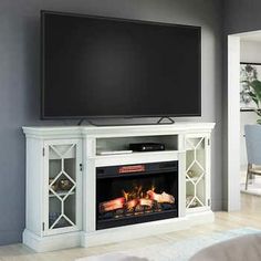 a flat screen tv mounted on top of a white fireplace