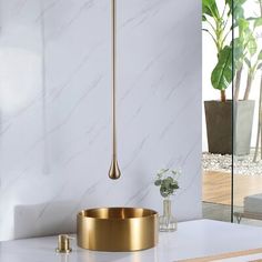 a bathroom with marble counter tops and gold fixtures