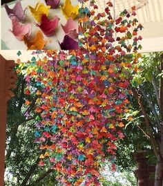 several different pictures of butterflies hanging from the ceiling and in front of a tree with no leaves on it