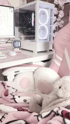 a white teddy bear sitting on top of a bed next to a computer monitor and keyboard