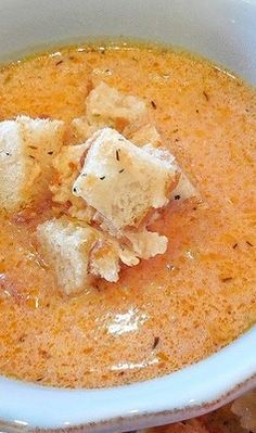 a white bowl filled with soup and bread