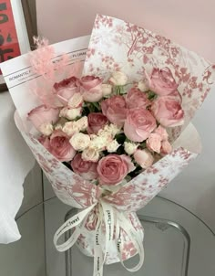 a bouquet of pink and white flowers sitting on top of a table