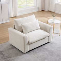 a white chair sitting on top of a rug in a living room next to a window