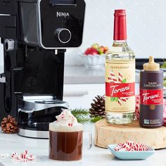 an espresso machine, hot chocolate and candy canes on a kitchen counter