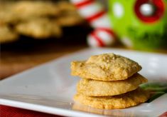 three cookies stacked on top of each other on a white plate with candy canes in the background