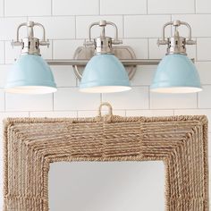 three light bathroom vanity fixture with blue shades on the lights and wicker basket underneath