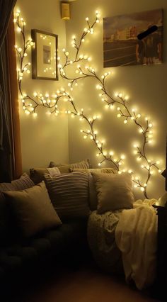 a living room with lights on the wall and a couch in front of it's headboard