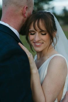 a bride and groom embracing each other outside