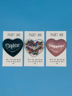 three heart shaped brooches with the words pocket hug, pocket hug and poopie hug