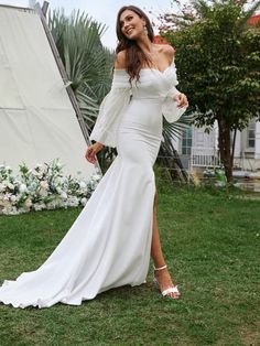 a woman in a white dress posing for the camera