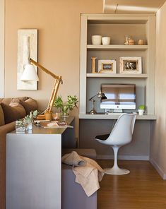 a living room with a desk, chair and bookshelf