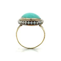 This exquisite Victorian cocktail ring captures the charm and elegance of the era. At its center is a stunning 5.83 carat oval cabochon cut turquoise, radiating a serene blue hue. Surrounding the turquoise are thirty-two delicate seed pearls, each measuring 1.5 mm, adding refinement to the ring. Crafted in polished 14 karat yellow gold, the bezel setting securely holds the turquoise, while the floral engravings on the band reflect the intricate craftsmanship of the Victorian period. Despite minor wear due to its age, this ring's delicate nature enhances its historical allure. Ideal for special occasions or as a collector's treasure, this Victorian cocktail ring exudes antique charm. Add this beautiful piece to your collection and enjoy a piece of history. Luxury Yellow Gold Turquoise Ring, Oval Cabochon, Thirty Two, Victorian Period, Seed Pearl, Delicate Rings, Oval Cabochon, Cocktail Ring, Blue Hues, Cocktail Rings