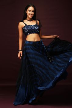 Blue tie dye lehenga with a flared silhouette and tie up on the side. Comes with sequin embroidered sleeveless blouse.
Component: 2
Pattern: Tie Dye and Embroidery
Type Of Work: Sequin
Neckline: Sweetheart
Sleeve Type: Sleeveless
Fabric: Luxury Satin
Color: Blue
Other Details: 
Tie dye tie up shoulder straps
Lehenga with side tie up and sequin embroidered tassel
Closure: Back hook
Occasion: Sangeet - Aza Fashions Sweetheart Blouse, Blouse Lehenga, Blue Luxury, Printed Skirt, Indian Fashion Designers, Satin Color, Pernia Pop Up Shop, Fashion App, Blue Tie