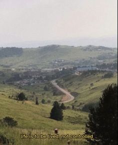 an image of a road going through the countryside with trees and hills in the background