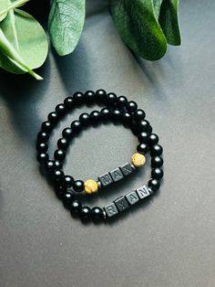 - Sleek and modern boys name bracelet with matte black onyx beads. Suitable for baby, toddler, or school age boys. Personalize with name, initials, nickname, sport ect... Lightweight stretch bracelet is beaded on high quality stretch cord and secured. ** lettering is very subtle black on black ** -  Choice of all black or black with brown bead accent. Please leave name or wording in personalization box. - 5.5 matte black onyx beads   6mm picture jasper beads   6mm acrylic matte black letter cubes     hematite spacer beads - Each purchase is sent in a velvet drawstring jewelry bag, making the perfect gift for son, back to school bracelet gift, boys birthday gift, baby shower gift or just because. - To care for your bracelet, please roll on and off wrist. Repeated stretching can wear the ela Personalized Black Name Jewelry, Personalized Black Jewelry With Name, Personalized Black Beaded Bracelets For Father's Day, Personalized Adjustable Black Bracelets, Personalized Black Beaded Bracelets, Adjustable, Personalized Black Bracelet, Minimalist Adjustable Black Name Bracelet, Personalized Black Minimalist Beaded Bracelets, Personalized Minimalist Black Beaded Bracelets