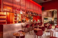 an empty restaurant with red chairs and tables