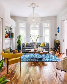 a living room filled with furniture and a fire place next to a window on top of a hard wood floor