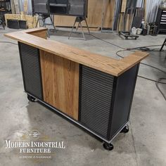 a large wooden counter sitting inside of a garage next to other furniture and tools on display