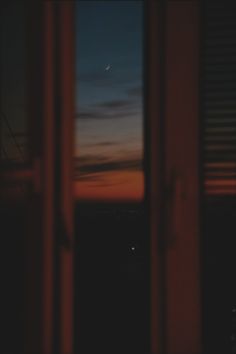 an open window at night with the moon in the sky