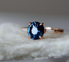 a blue ring sitting on top of a white piece of cloth