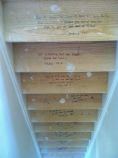 the bottom half of a wooden shelf with writing on it and some wood planks