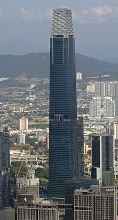 an aerial view of a city with skyscrapers in the foreground and mountains in the background