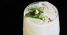 a close up of a drink in a glass on a black background with sprinkles