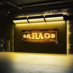 an empty garage with the word garage lit up on it's wall and floor