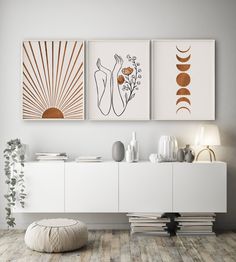 three framed art pieces hang on the wall above a white cabinet and sideboard in a modern living room